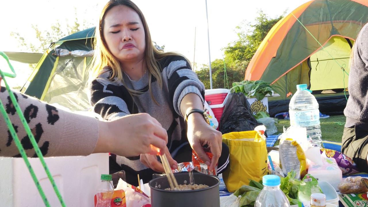 亚洲妇女在大自然中吃烤猪肉。视频素材