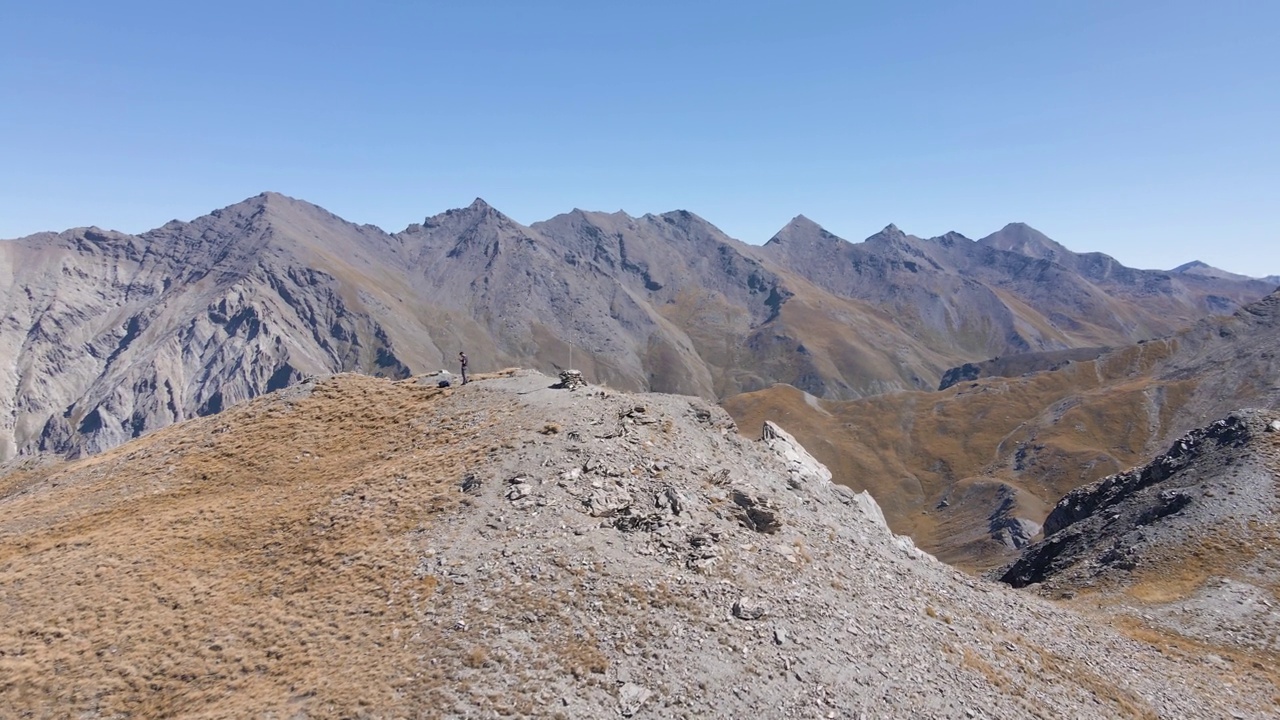 无人机拍摄的一个徒步旅行者站在山顶上视频素材