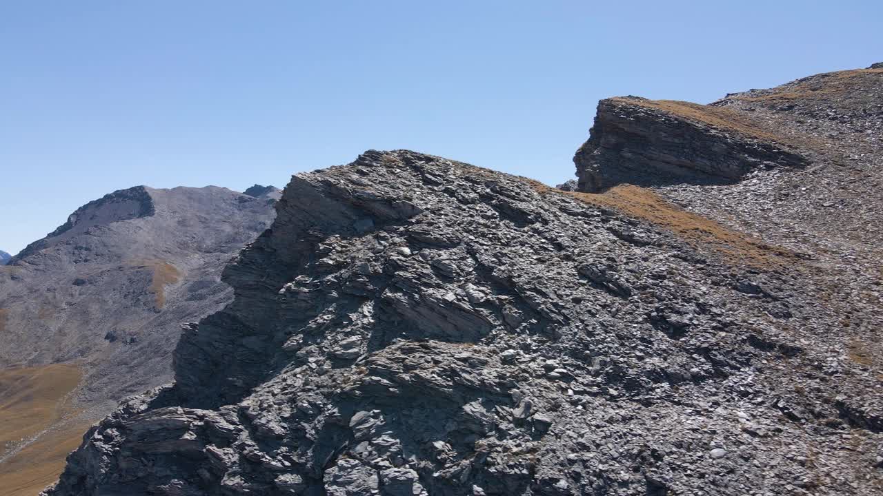 无人机拍摄的一个徒步旅行者站在岩石山峰上视频素材