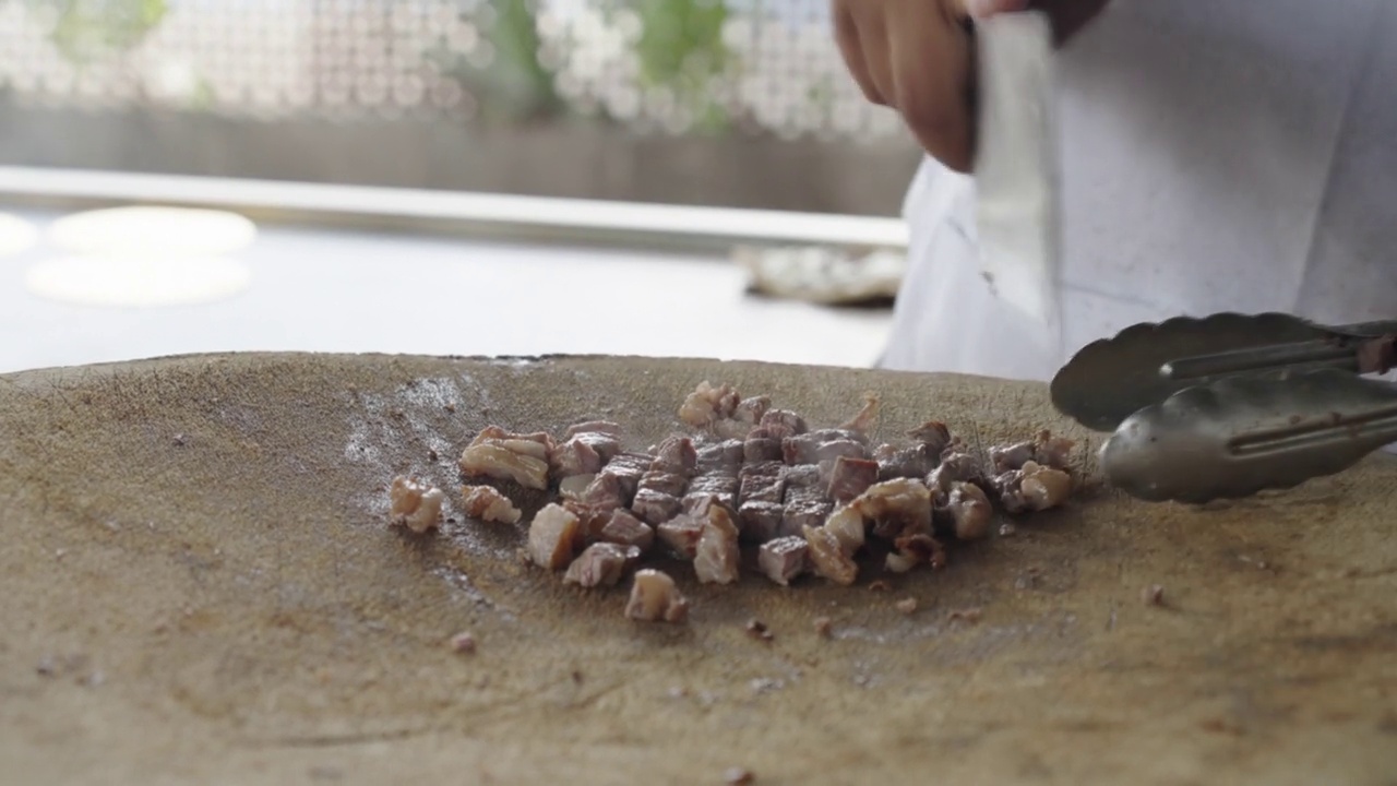 墨西哥马萨特兰的一家露天塔可餐厅里，厨师在质朴的砧板上切Carne Asada牛排视频素材