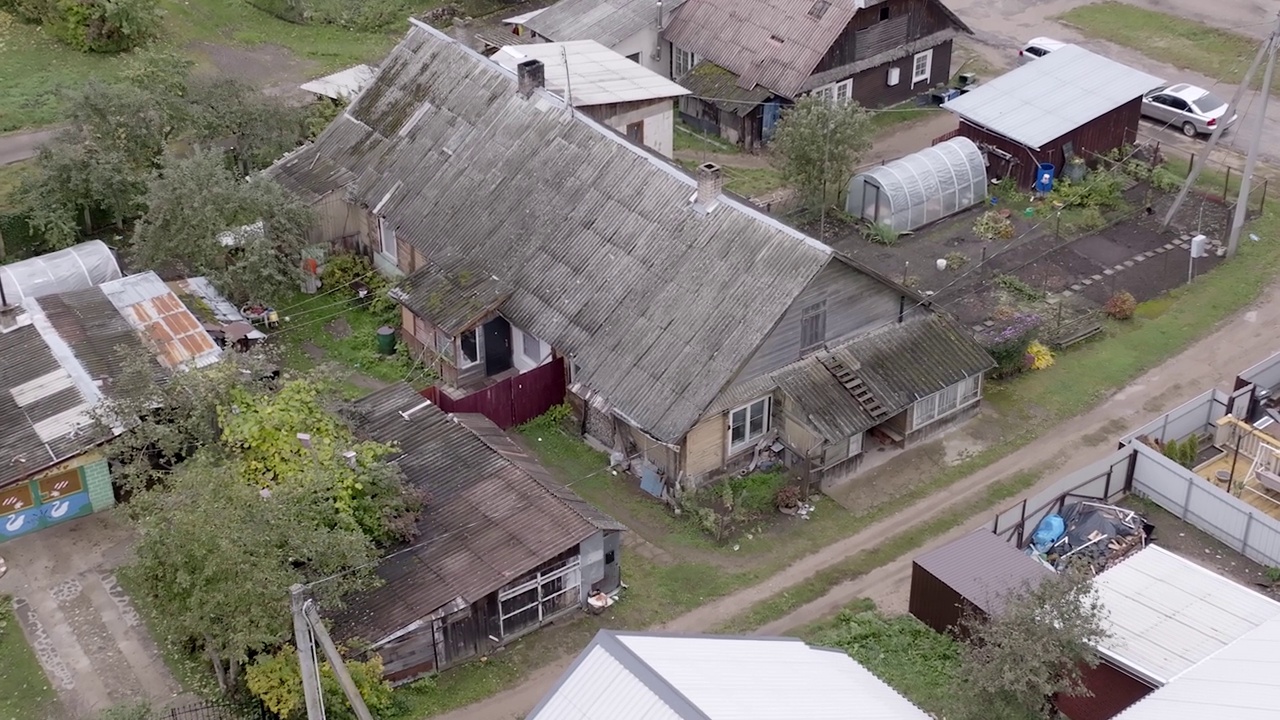 空中拍摄到的乡村房屋的旧屋顶和沿着建筑的小路视频素材