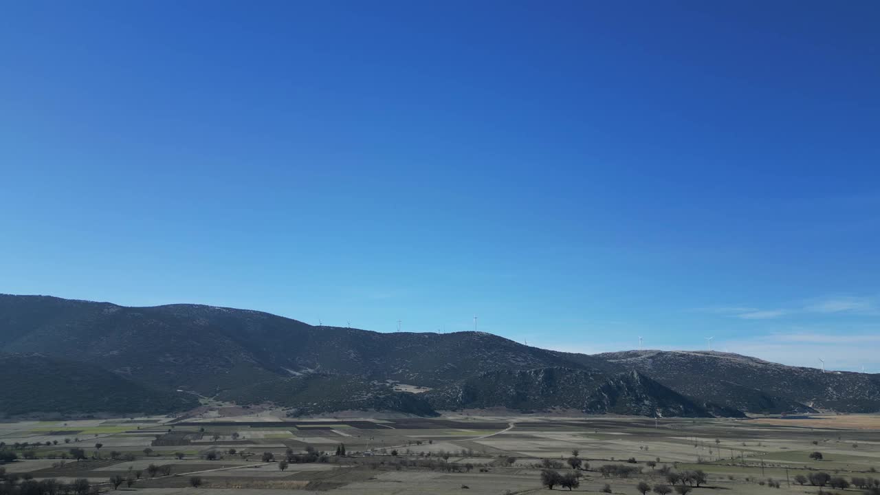 镜头从远处飞向位于山脊上的风车视频素材