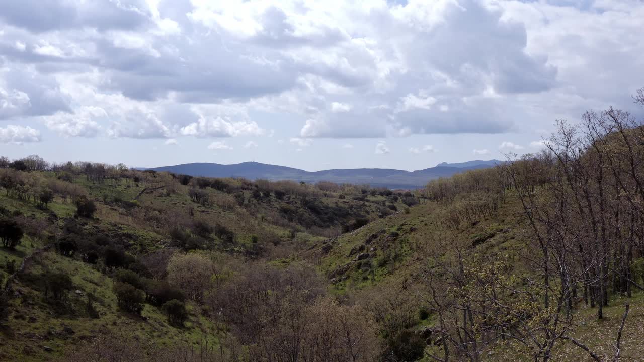 视频用无人机拍摄了阳光明媚的秋季山地景观，有云、树、植物和岩石。视频下载