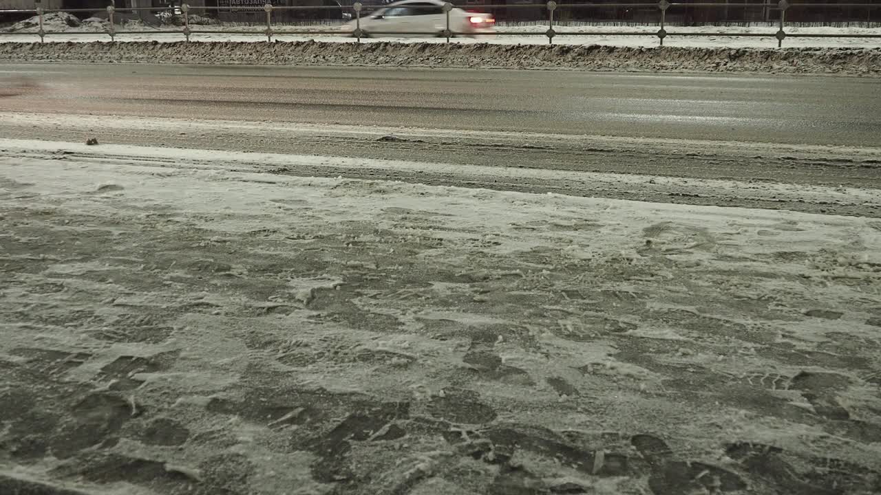 冰城道路。湿沥青。困难的驾驶条件。汽车在开车。雪在路上漂着。冬天的雪融化了。Perevalka区Chapaeva街视频素材