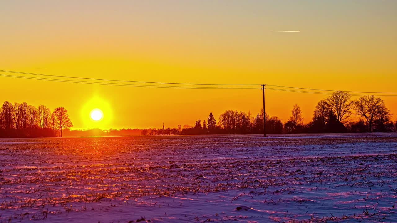 时间推移的太阳充满活力的颜色消失在黄色的天空上的雪景，天空为复制空间视频素材