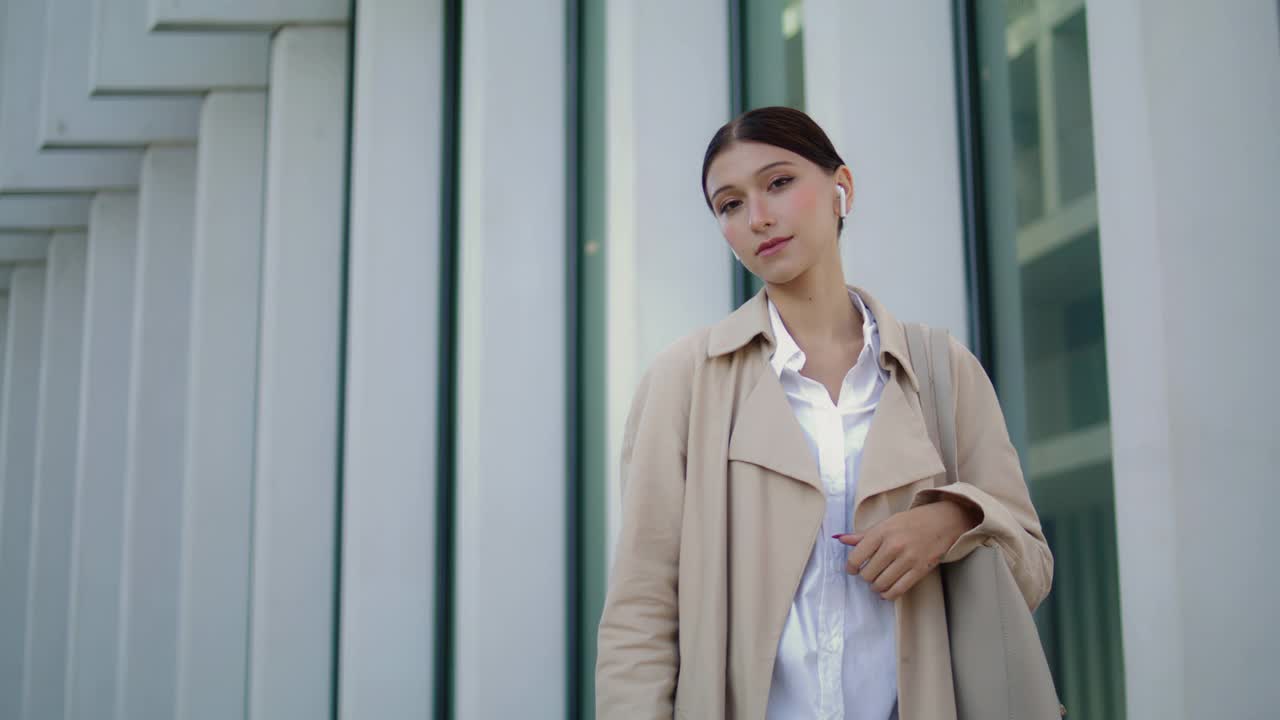 吸引人的模特在建筑物附近的街道上摆姿势。优雅女子画像视频素材