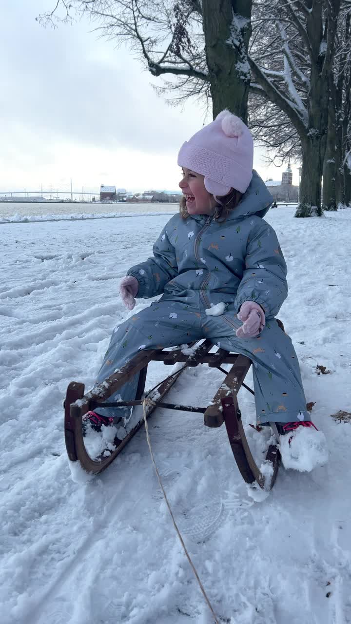 快乐的白人小女孩坐在雪橇上大笑视频素材