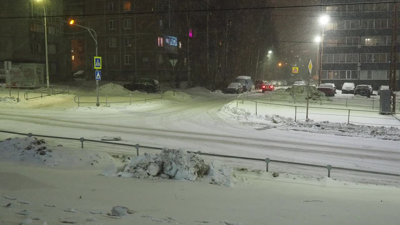 冰路。湿沥青。困难的驾驶条件。汽车在开车。降雪,灯笼。雪堆和暴风雪视频素材