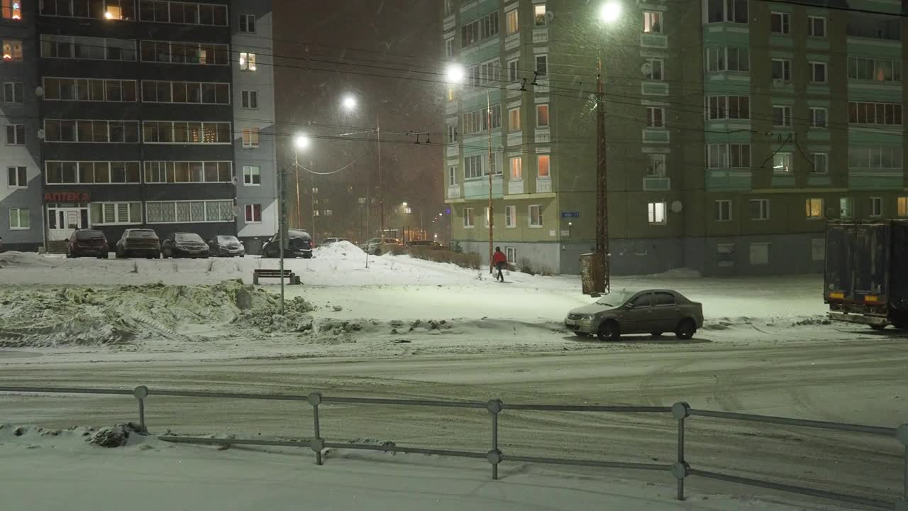 冰路。湿沥青。困难的驾驶条件。汽车在开车。路人。降雪,灯笼。雪堆和暴风雪视频素材