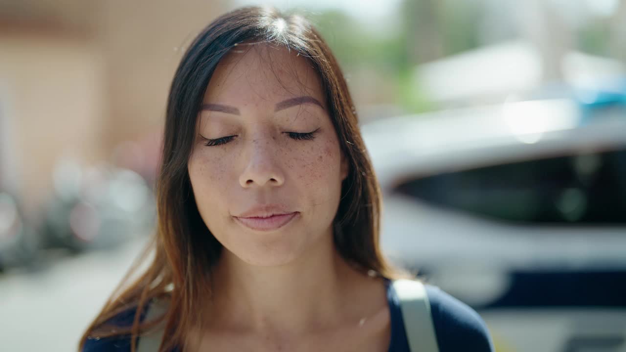 年轻的亚洲女子微笑自信站在街上视频素材