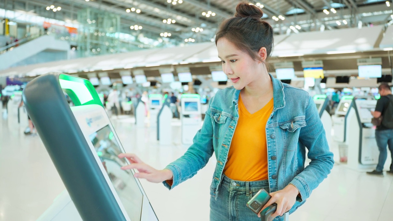 亚洲年轻女旅客在机场候机楼柜台办理登机手续。迷人美丽的女游客朋友心情愉快，兴奋地乘飞机出国旅游度假旅行视频素材