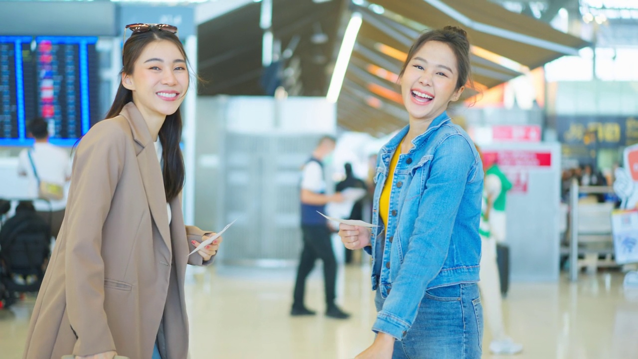 亚裔女性站在机场候机厅的登机口。迷人美丽的女游客旅客感到快乐和兴奋，去国外旅游的飞机假期旅行。视频素材