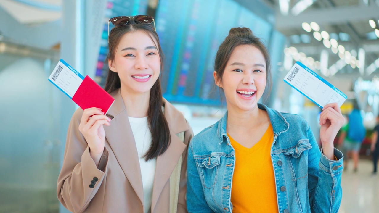 亚裔女性站在机场候机厅的登机口。迷人美丽的女游客旅客感到快乐和兴奋，去国外旅游的飞机假期旅行。视频素材