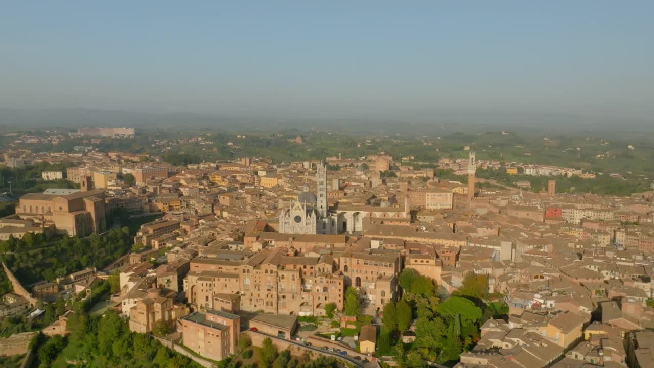 空中平移拍摄的Duomo Di Siena教堂在阳光灿烂的一天在城市的建筑物视频素材