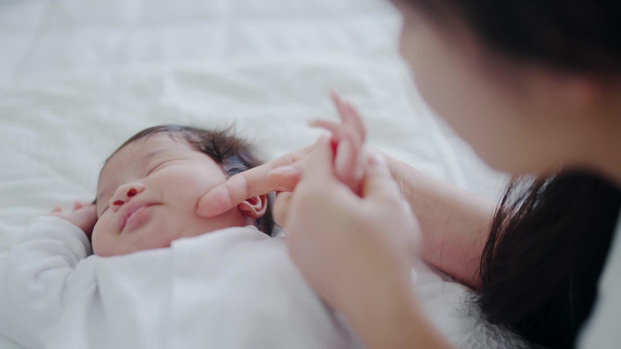 新生的婴儿被他的妈妈抱着亲吻。视频素材