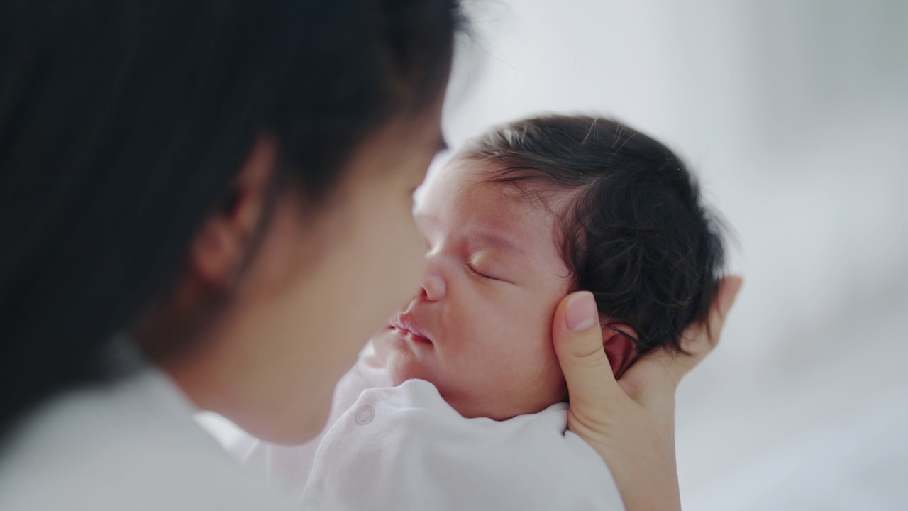 一位母亲拥抱并亲吻她刚出生的孩子视频素材