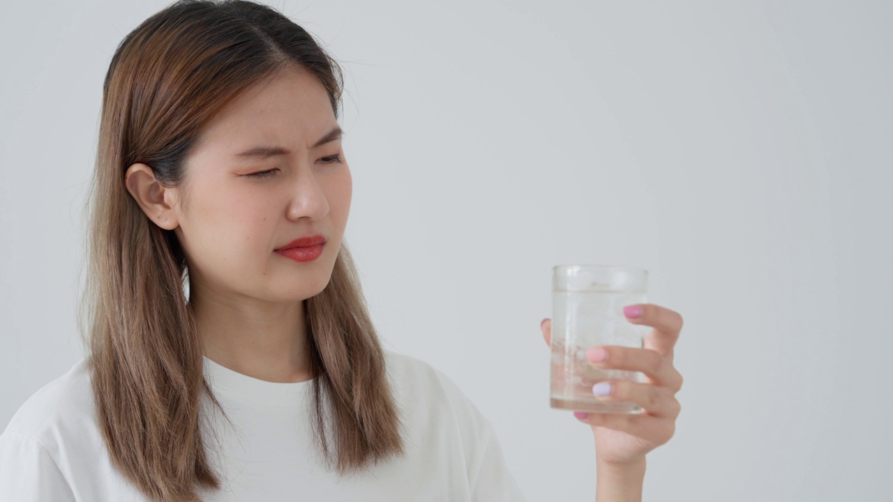 亚洲女性喝冷饮后感觉牙齿敏感，女性患牙、蛀牙问题，牙科护理，拔牙、蛀牙问题，口臭，牙龈萎缩，口腔卫生指导视频素材