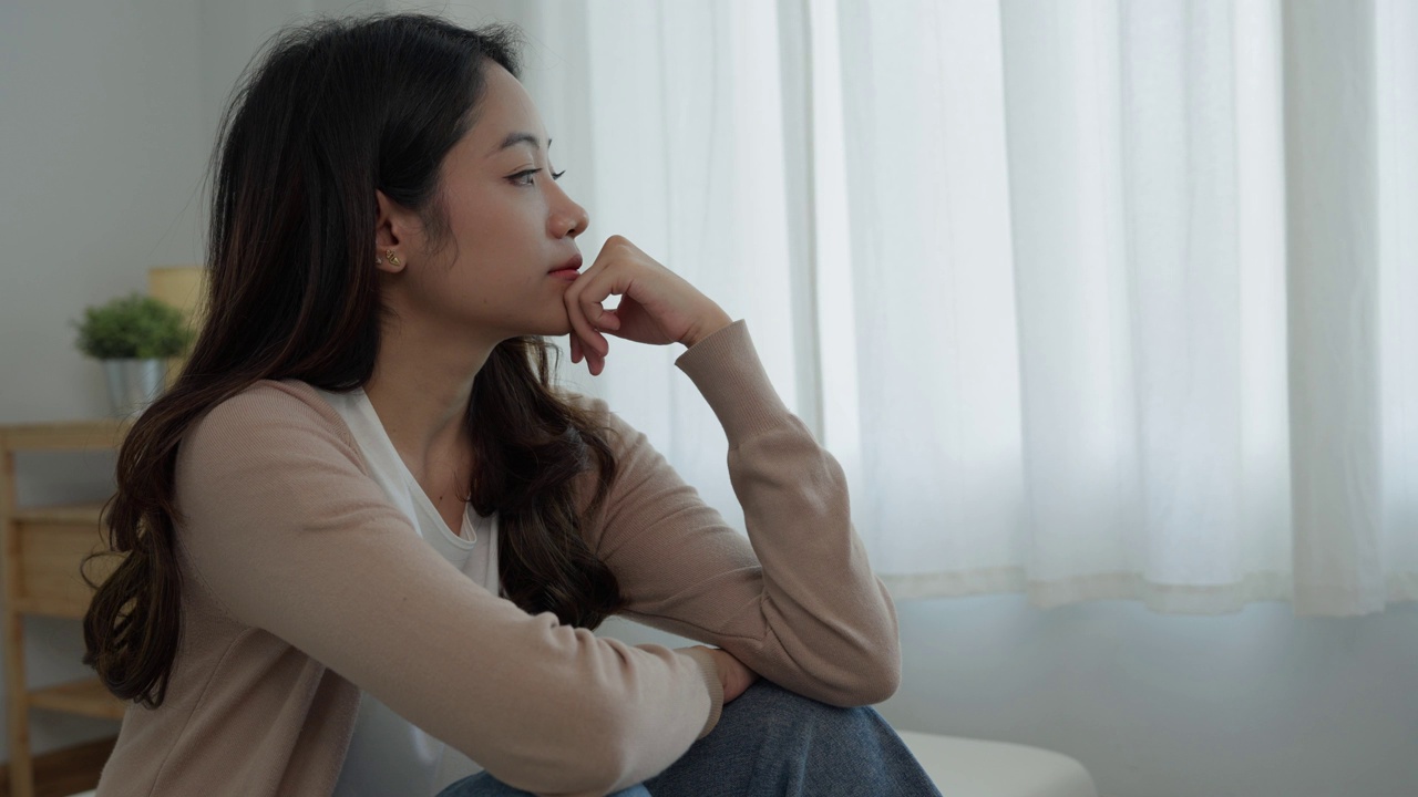 不快乐的亚洲女性女孩失望，独自在家为问题感到悲伤，感到孤独，压力大，遭受糟糕的关系，分手，离婚，女性困惑，抑郁心理健康，孤独视频素材