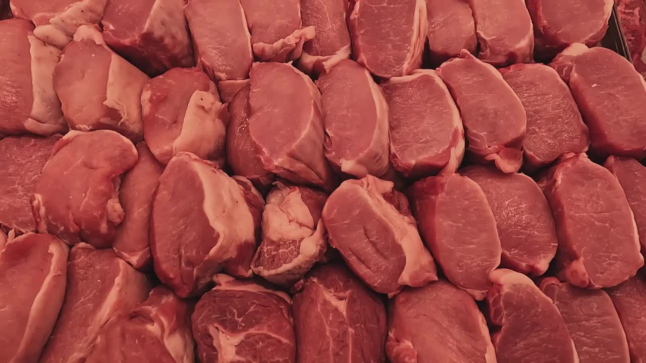 陈列在商店里。肉猪肉。零售业的特写。商场里卖猪肉。肉店出售生肉。大卖场的肉类部。倾斜。视频素材