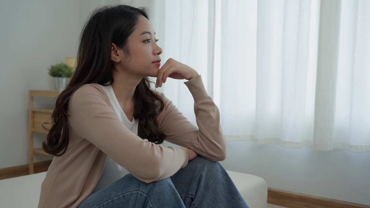 不快乐的亚洲女性女孩失望，独自在家为问题感到悲伤，感到孤独，压力大，遭受糟糕的关系，分手，离婚，女性困惑，抑郁心理健康，孤独视频素材