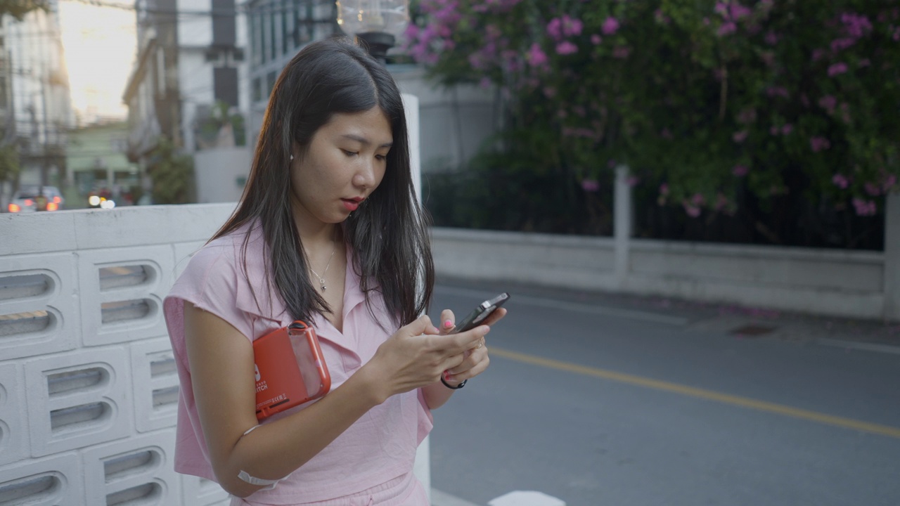 女孩坐在外面用智能手机视频素材