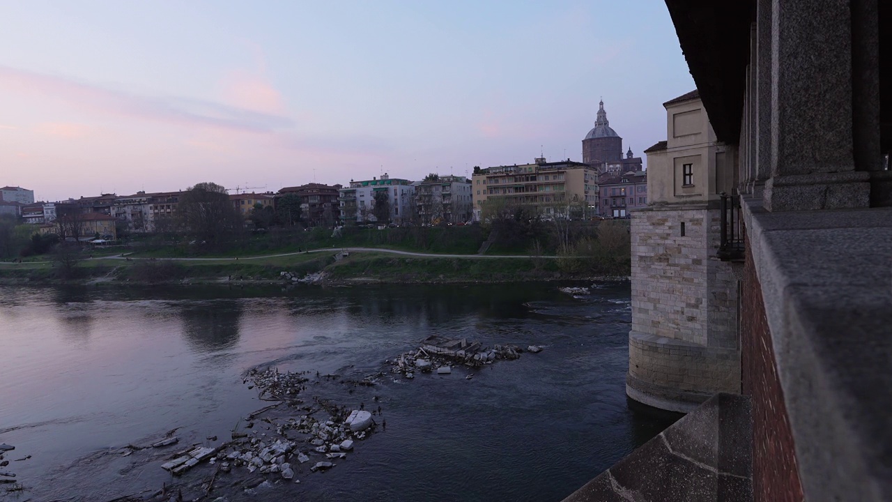 在日落60帧/秒的帕维亚，Ponte Coperto(有盖桥)和Duomo di Pavia(帕维亚大教堂)视频素材