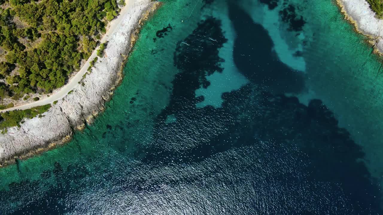 在克罗地亚达尔马提亚的赫瓦尔岛上，鸟瞰绿松石水湾的海滩和游艇视频素材