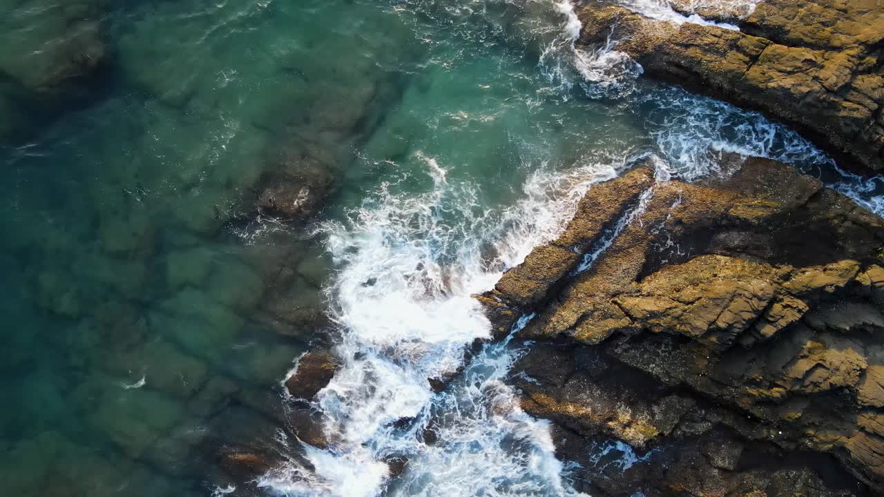 阳光照射下清澈的绿色海水使岩石清晰可见。视频素材