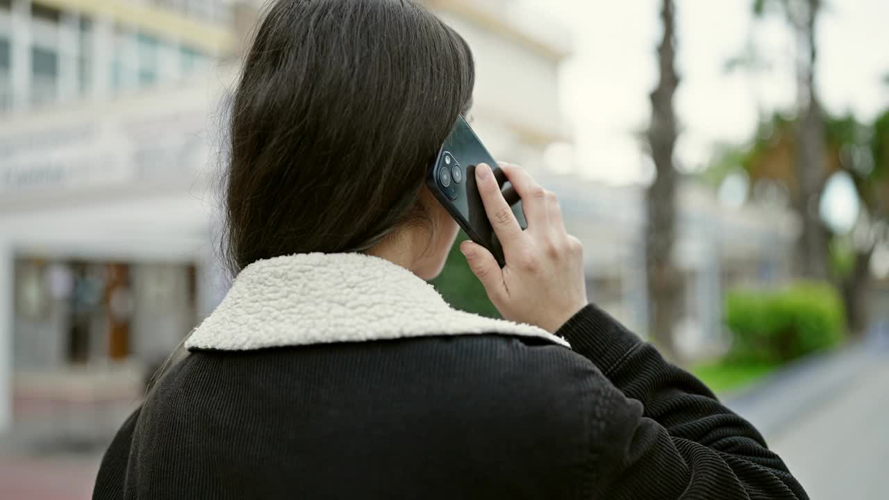 年轻漂亮的西班牙女人在公园用智能手机聊天视频素材