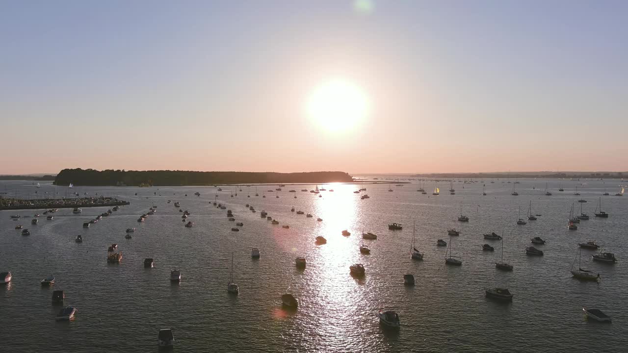 英国普尔:英国大西洋边著名海滨度假城市海面上夕阳反射的鸟瞰图，夏季的沙洲社区——从空中俯瞰英国的全景景观视频素材