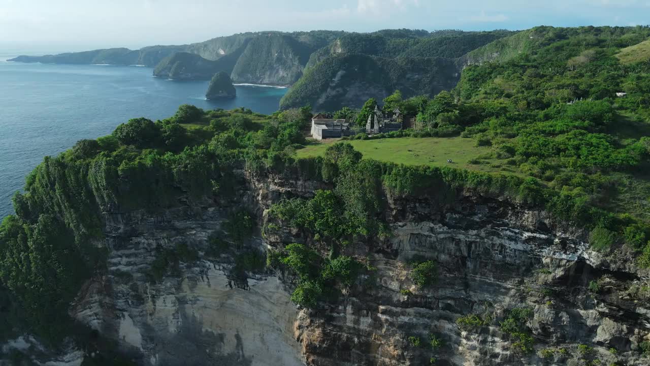 海岸线上有巴厘岛寺庙和努萨佩尼达的岩石悬崖。鸟瞰风景优美的岛屿视频素材