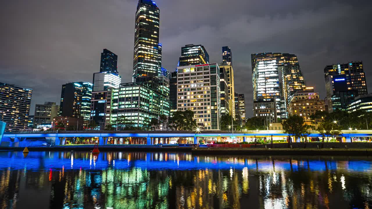 时间推移的墨尔本城市景观与雅拉河海滨和城市的火车在晚上附近弗林德街火车站在墨尔本，维多利亚州，澳大利亚视频素材