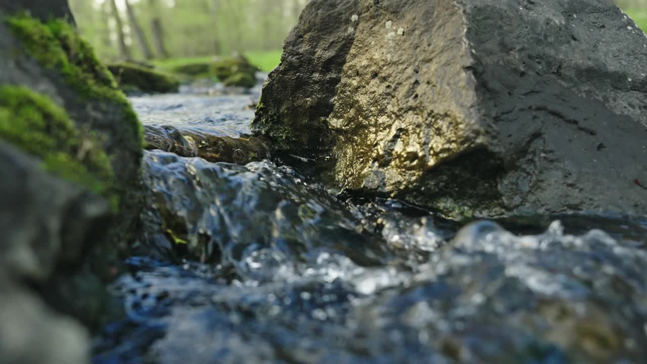 在岩石之间流动的清水的SLO MO特写视频素材