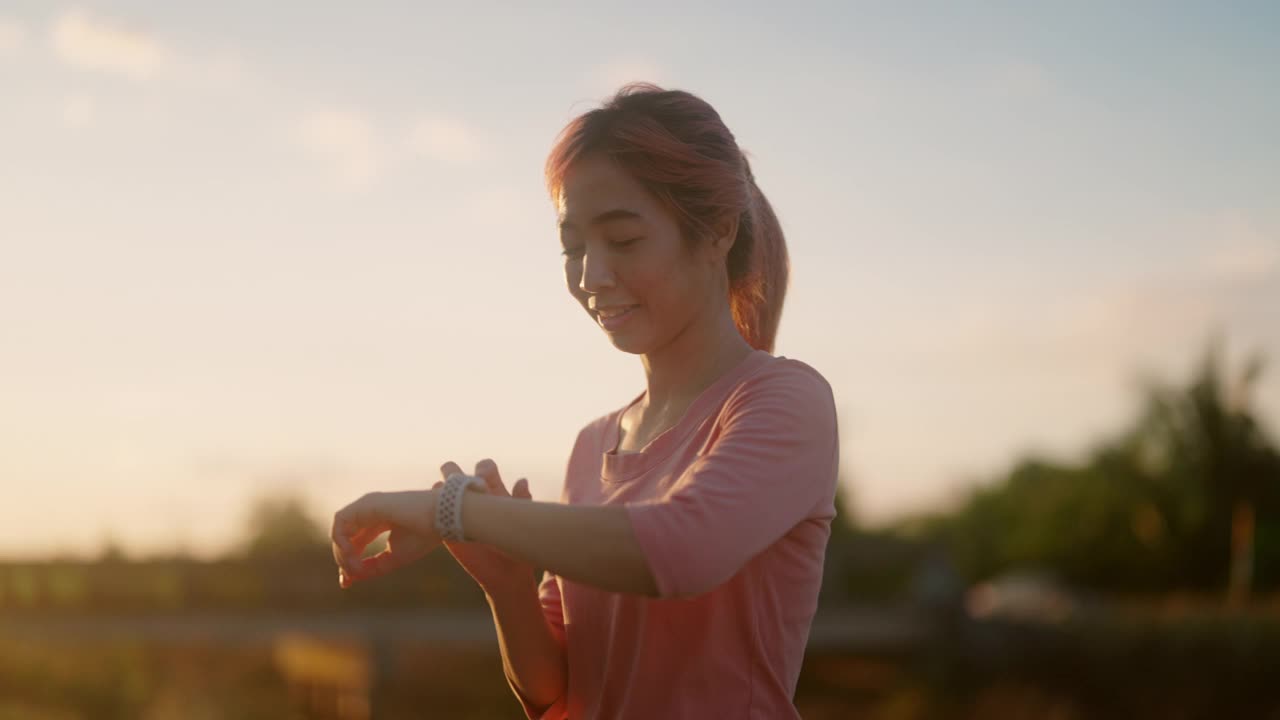 女子用智能手表跟踪跑步情况视频素材