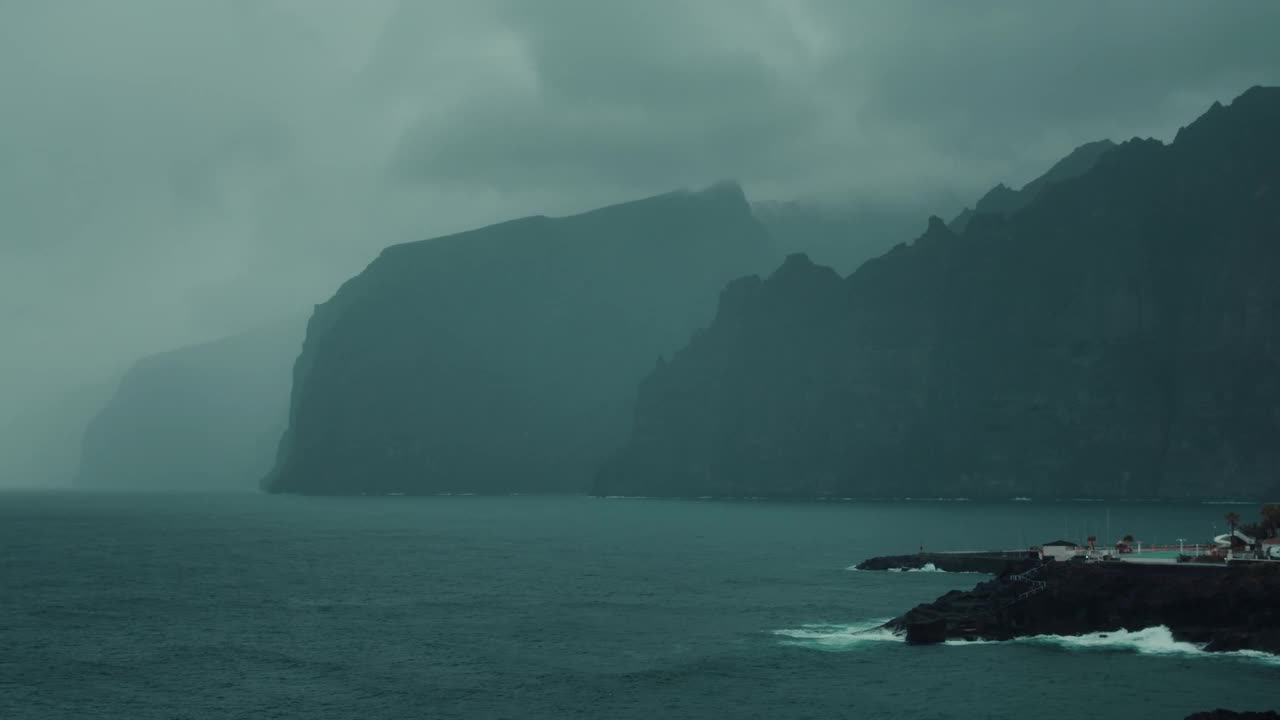 阴天，多岩石的海滩上阴雨连绵，乌云密布。风暴飓风前灰色平静的海面。视频素材