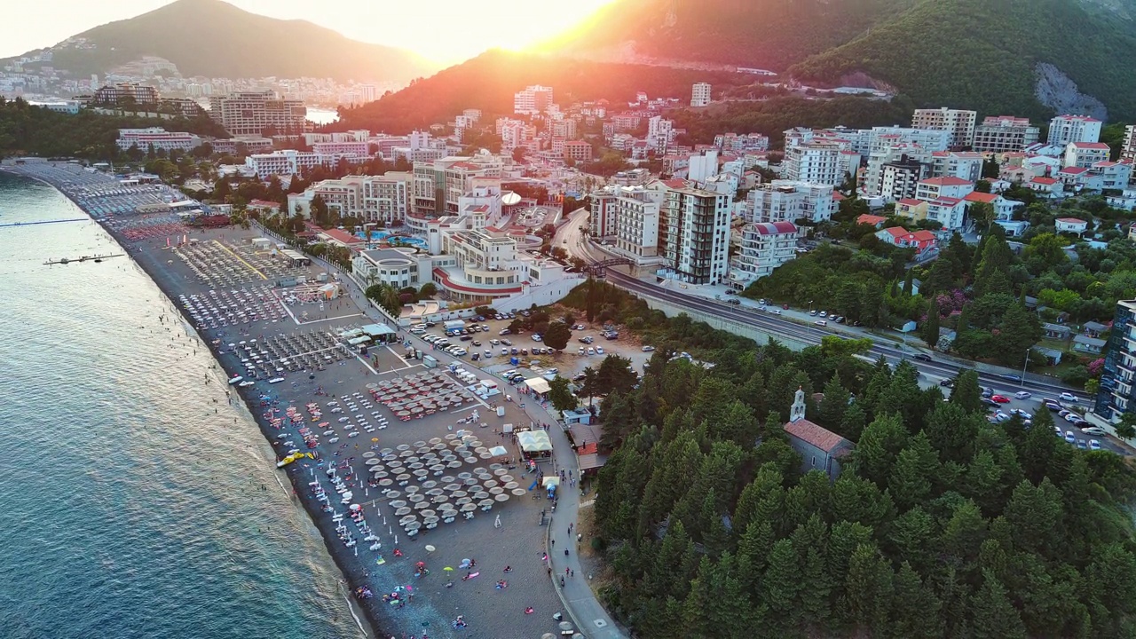 海滩上有遮阳伞、日光浴床，人们在亚得里亚海附近的贝西镇放松，背景是阳光明媚的天空视频素材