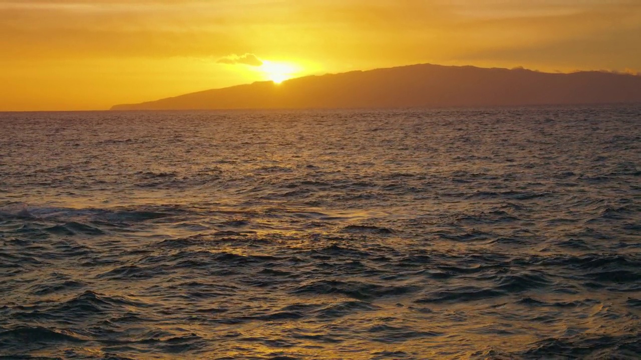 最后一缕橙色的夕阳落在戈梅拉岛和海洋上。落日背景下的海浪。视频素材