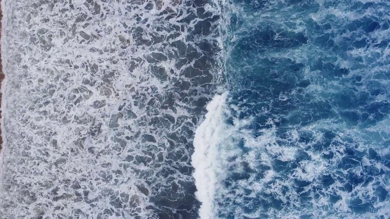 俯视图的海滩海浪泡沫来到沙滩视频素材