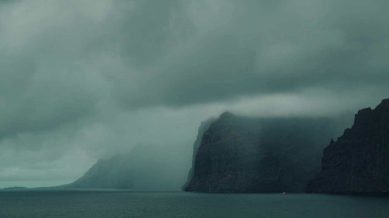 阴天里，风景如画的岩石海滩上乌云密布。风暴飓风前灰色平静的海面。视频素材