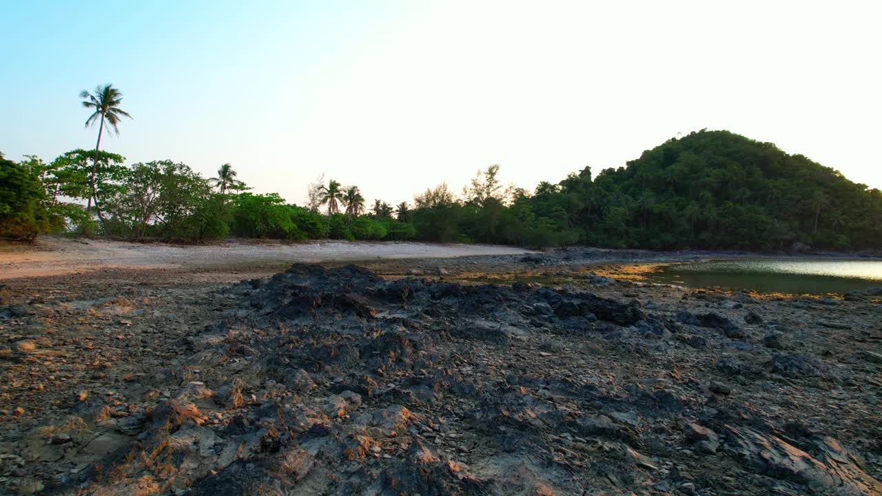 夕阳下漫步在岩石沙滩上视频素材