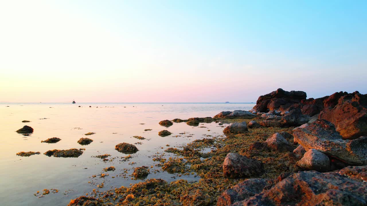 夕阳下漫步在岩石沙滩上视频素材