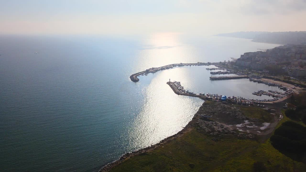 航拍到的汽车在河对岸的道路和城市建筑上行驶视频素材