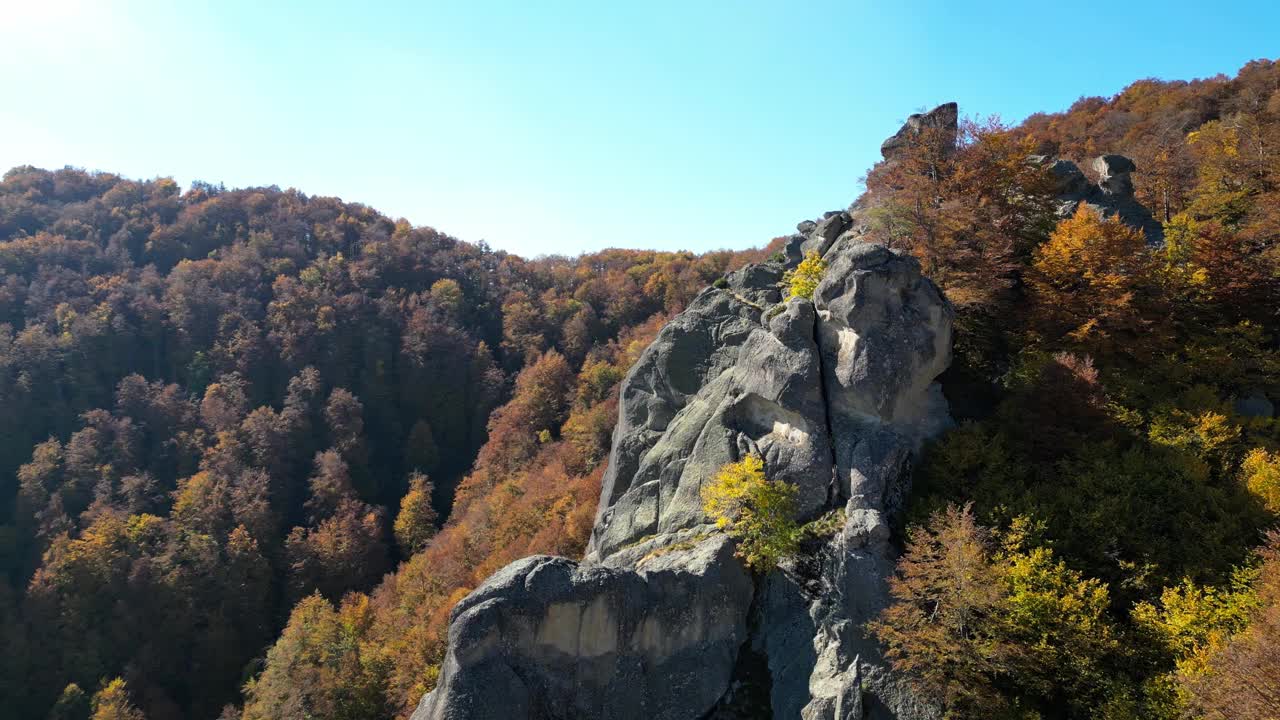 在阳光明媚的日子里，茂密的山脉和岩石悬崖的秋天景观视频素材