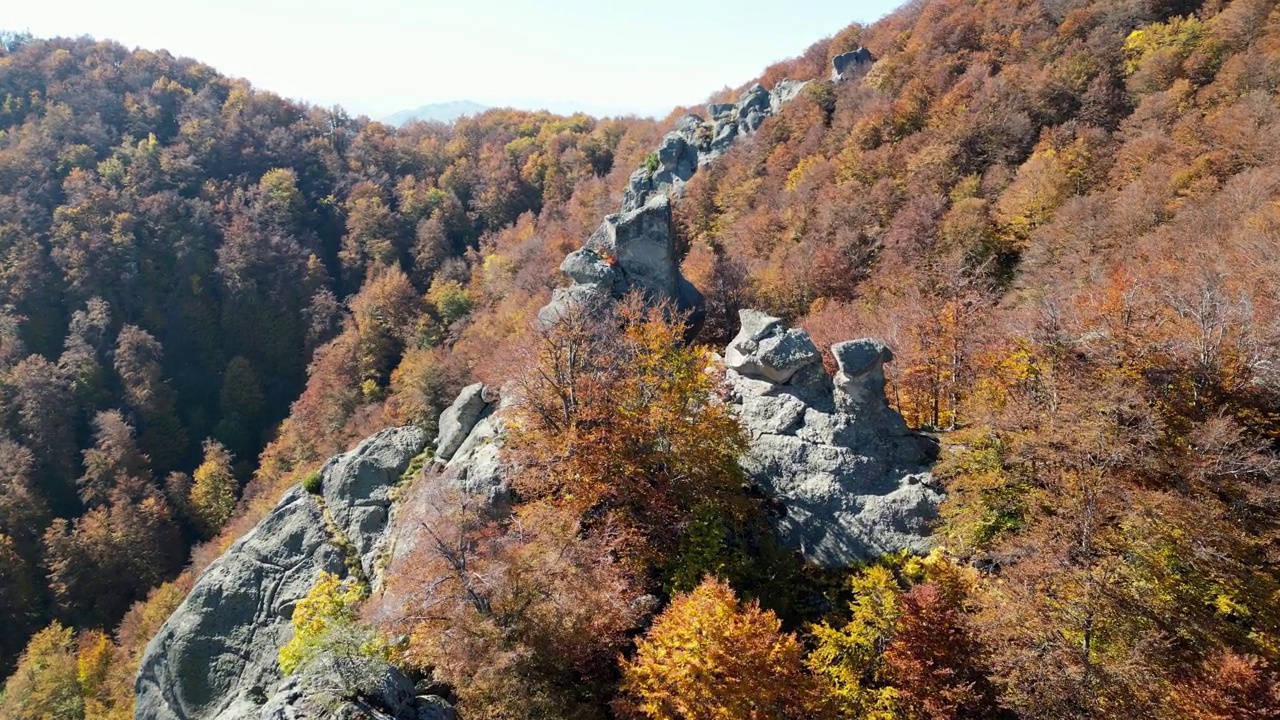 在阳光明媚的日子里，茂密的山脉和岩石悬崖的秋天景观视频素材