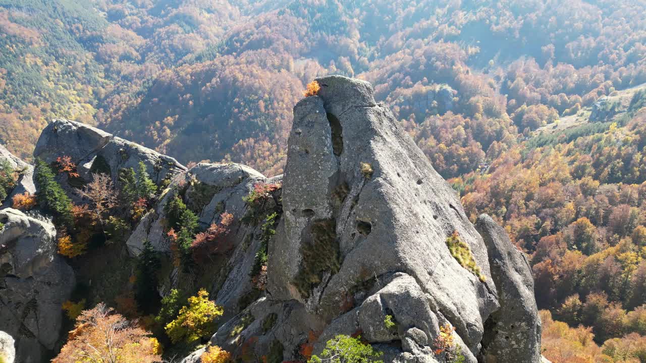 在阳光明媚的日子里，茂密的山脉和岩石悬崖的秋天景观视频素材