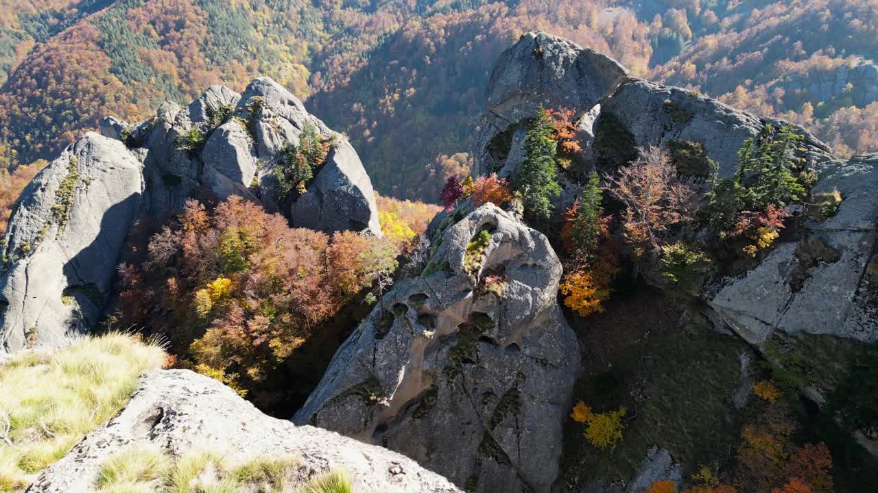 无人机在阳光下植被繁茂的岩石山丘上拍摄视频素材