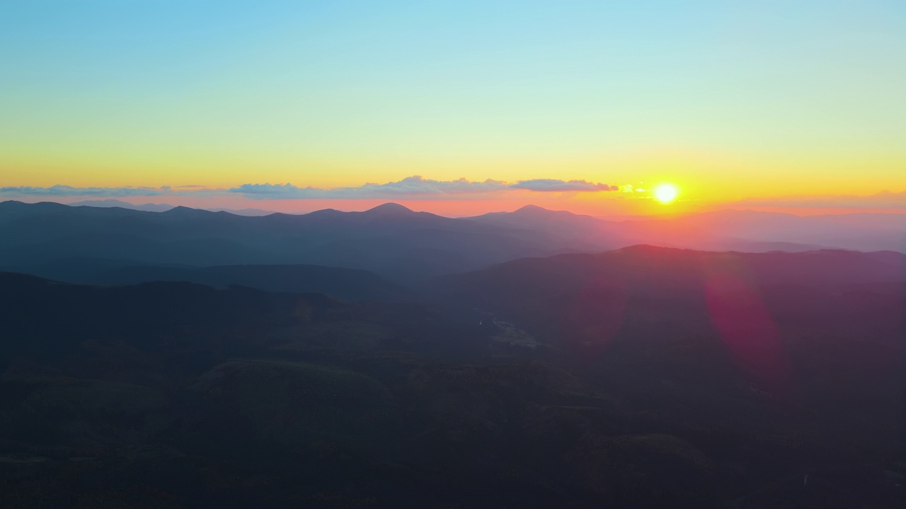 鸟瞰图，日落时，黑暗的山与明亮的夕阳。黄昏朦胧的山峰和朦胧的山谷视频素材