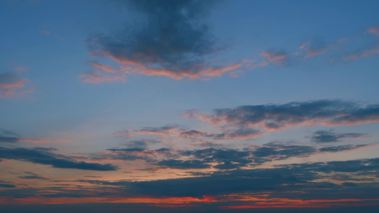 红橙晚霞的天空。日落时大海或海洋上令人惊叹的天空。云景延时背景。时间流逝。视频素材