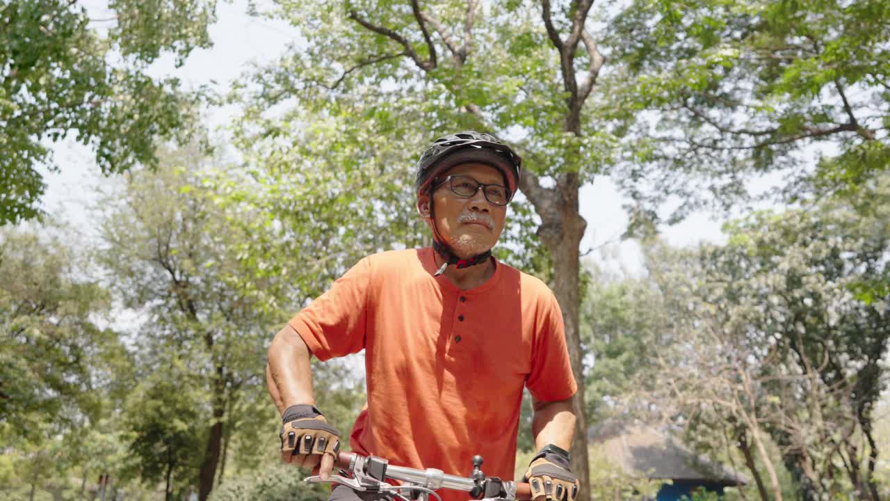 亚洲老年华人男子骑自行车视频素材