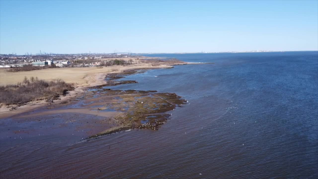 空中拍摄的平静的海浪拍打着海岸，背景是地平线视频素材